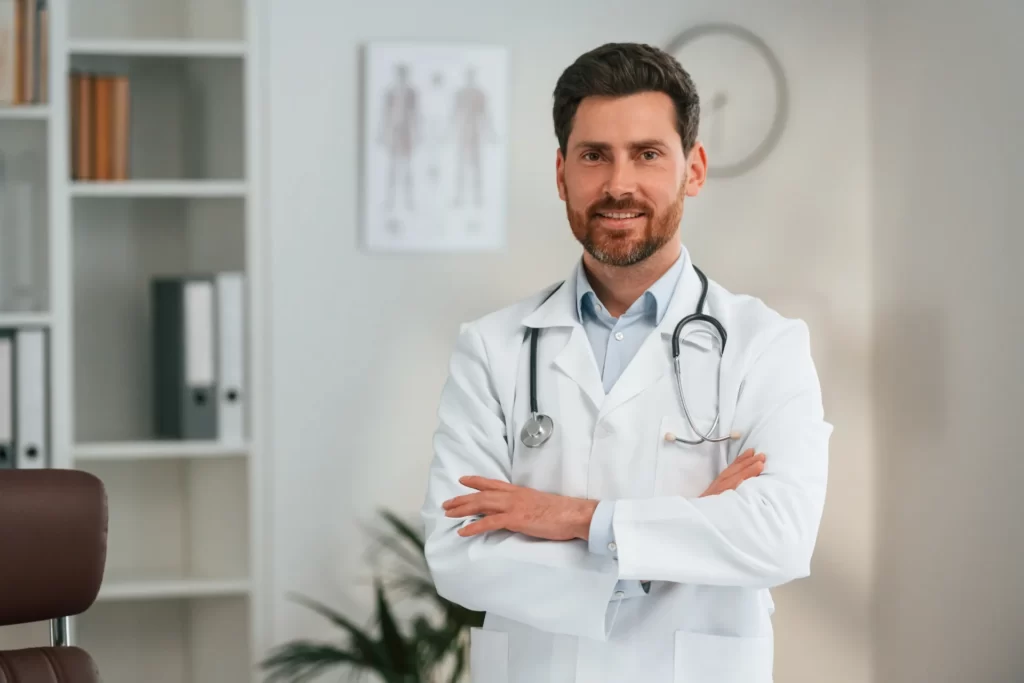 confident doctor poses with stethoscope in office utc